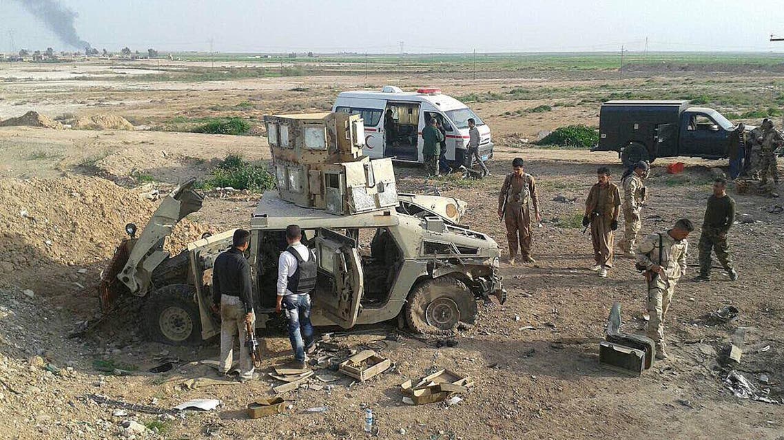 Kurdish soldiers investigate the inside of a vehicle abandoned by Islamic State group militants in Kirkuk, 180 miles (290 kilometers) north of Kirkuk, Iraq. Monday, March 16, 2015. AP