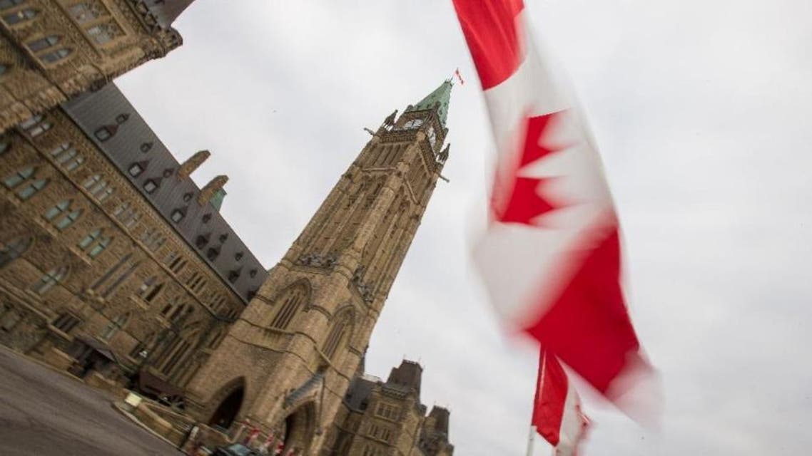 A Canadian flag flies in front of the peace tower on Parliament Hill in Ottawa, Canada on December 4, 2015 (AFP Photo/Geoff Robins)