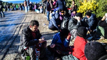 Migrants wait at the side of the road after being detained by Turkish soldiers as they try to reach the Greek island of Lesbos from Dikili, western Turkey, on March 5, 2016 (AFP)