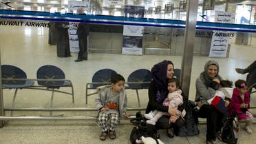 Passengers sit outside the Kuwait Airways terminal area at the Kuwait International Airport, in this March 18, 2012 file picture. (Reuters)