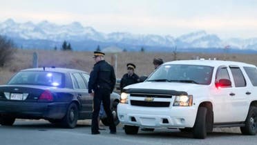 Royal Canadian Mounted Police (RCMP) officers man a road block leading to a Muslim cemetery near Cochrane, Canada, on Friday (March 11, 2016). RCMP said at least three people have been shot at the cemetery just outside of Calgary. (AP)