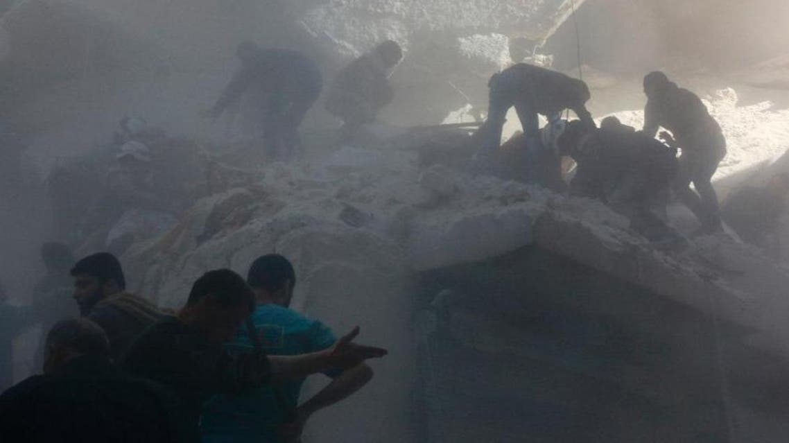Syrian rescue workers and residents try to pull a man out from under the rubble of a building following a reported air strike on the rebel-held neighbourhood of Salhin in the northern city of Aleppo on March 11, 2016 (AFP)