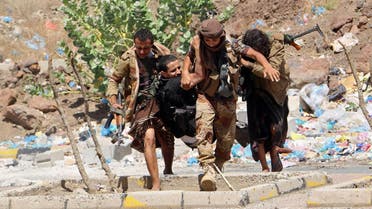 Fighters from local resistance units carry a fellow fighter who was injured in clashes between local fighters and Shiite rebels known as Houthis, in Taiz, Yemen, Friday, March 11, 2016. Yemeni medical officials say clashes between Shiite rebels and local fighters in the besieged city of Taiz have intensified, killing several dozen people on both sides over the past 24 hours. (AP Photo/Abdulnasser Alseddik)