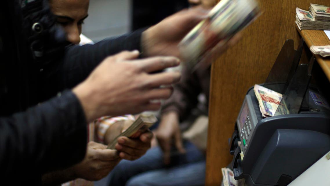 Egyptians count money at a currency exchange office in downtown Cairo, Egypt (AP)