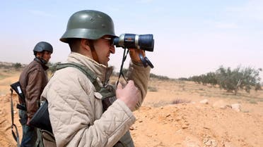 A policemen looks through a binocular during a military operation to eliminate militants in a village some 50 km (31 miles) from the town of Ben Guerdane, Tunisia, near the Libyan border, March 10, 2016 (Reuters)
