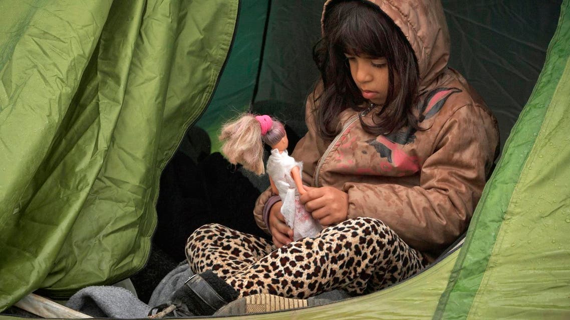 A girl holds a doll while sitting in a tent at the northern Greek border station of Idomeni, Saturday, March 12, 2016. Up to 14,000 people are stranded on the outskirts of the village of Idomeni in a makeshift camp. (AP Photo/Vadim Ghirda)