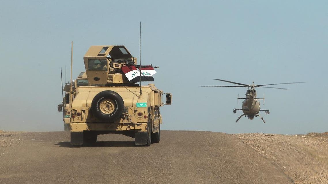 Iraqi army vehicles and a helicopter deploy in the front line in al-Anbar desert, 50 kms north east of Haditha, where the country's forces are fighting the Islamic State (IS) jihadist group, on March 9, 2016 (AFP)