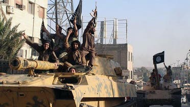 In this undated file image posted by the Raqqa Media Center in Islamic State group-held territory, on Monday, June 30, 2014, which has been verified and is consistent with other AP reporting, fighters from the Islamic State group ride tanks during a parade in Raqqa, Syria. (Raqqa Media Center via AP)