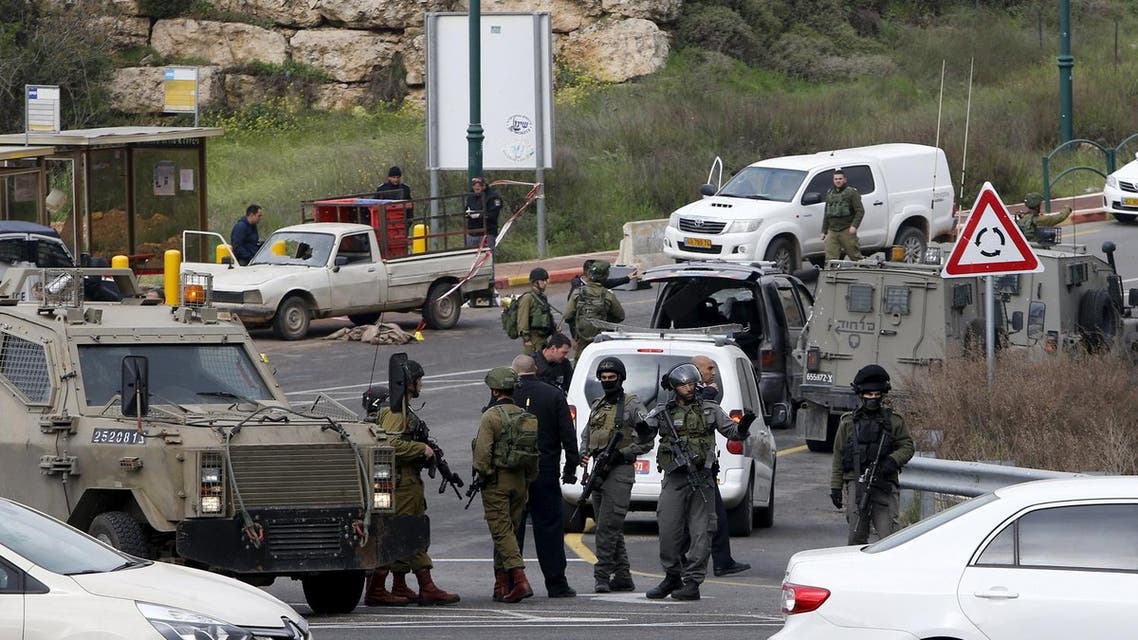 Israeli security forces gather near the scene of what the Israeli military said were back-to-back gun and car-ramming attacks by Palestinians, near the Jewish settlement of Kiryat Arba near the West Bank city of Hebron March 14, 2016. Three Palestinians carried out back-to-back gun and car-ramming attacks on Israelis near a Jewish settlement in the occupied West Bank on Monday and were shot dead by the army, it said. REUTERS