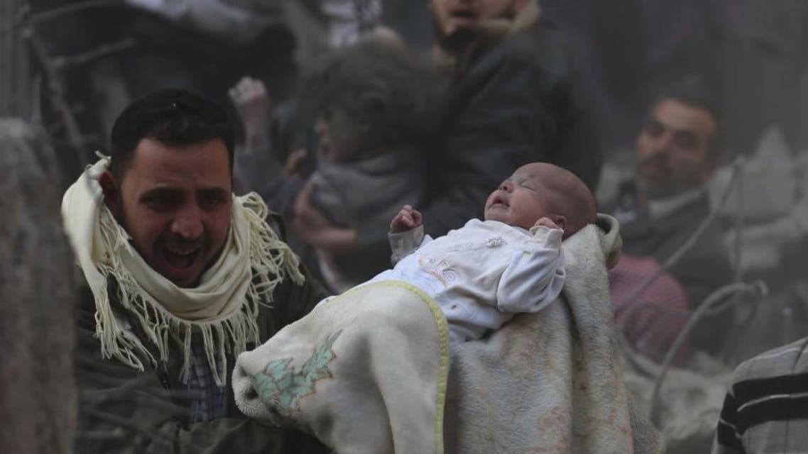 A man carries a baby who survived what activists say was an airstrike by forces loyal to Syrian President Bashar al-Assad in the Duma neighbourhood of Damascus January 7, 2014. (Reuters)