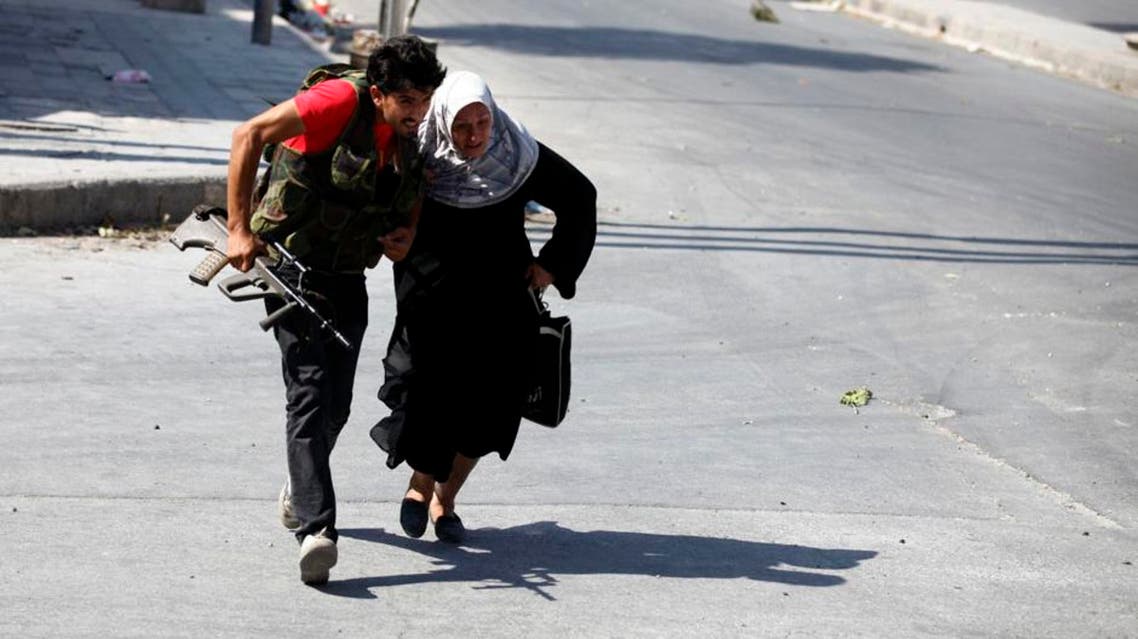 A woman runs from open fire as she attempted to go back home with her husband to retreive things from Aleppo. (Reuters)