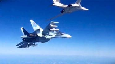 a Russian air force Tu-160 bomber, right, is escorted by an Su-30SM on a combat mission against a target in Syria. 
