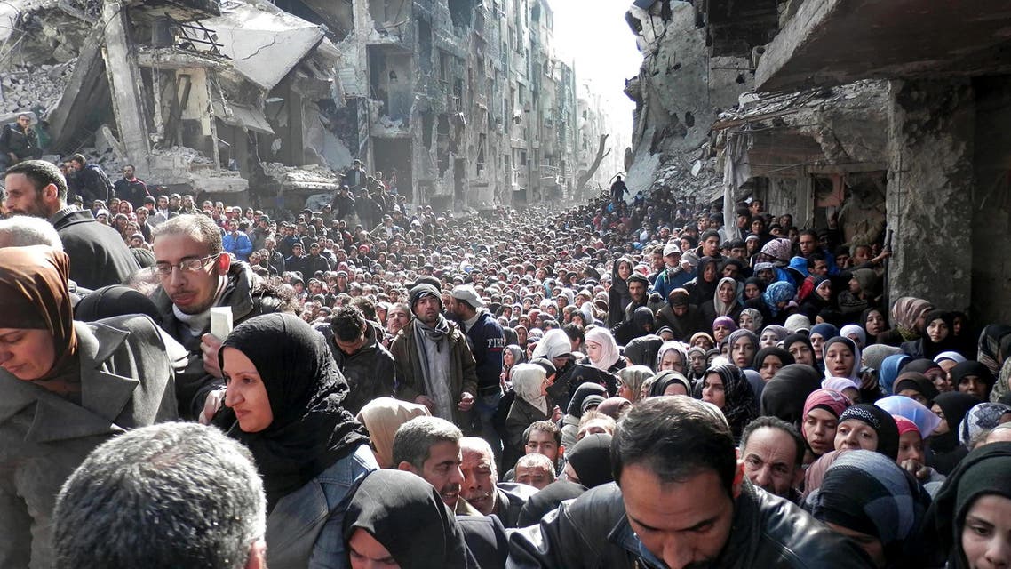 Residents of the besieged Palestinian camp of Yarmouk, queuing to receive food supplies, in Damascus, Syria in 2014. (UNRWA via AP)