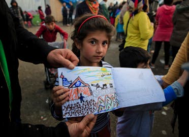 Shaharzad Hassan, 8 year-old from the Syrian city of Aleppo poses with a drawing she made at the northern Greek border station of Idomeni, Friday, March 11, 2016. At an overcrowded refugee camp on the Greek-Macedonian border, 8-year-old Shaharzad Hassan draws pictures of the harrowing events in her life over the past 18 months: Pictures of death in her home town of Aleppo, Syria, and her perilous journey to Europe. The title this drawing seen top right reads 