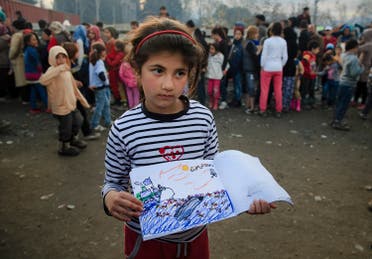 Shaharzad Hassan, 8 year-old from the Syrian city of Aleppo poses with a drawing she made, depicting a migrants rescue operation by the Greek navy, as people wait in line for food rations at the northern Greek border station of Idomeni, Friday, March 11, 2016. At an overcrowded refugee camp on the Greek-Macedonian border, 8-year-old Shaharzad Hassan draws pictures of the harrowing events in her life over the past 18 months: Pictures of death in her home town of Aleppo, Syria, and her perilous journey to Europe. (AP Photo/Vadim Ghirda)
