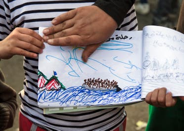 Shaharzad Hassan, 8 year-old from the Syrian city of Aleppo poses with a drawing she made, at the northern Greek border station of Idomeni, Friday, March 11, 2016. At an overcrowded refugee camp on the Greek-Macedonian border, 8-year-old Shaharzad Hassan draws pictures of the harrowing events in her life over the past 18 months: Pictures of death in her home town of Aleppo, Syria, and her perilous journey to Europe. (AP Photo/Vadim Ghirda)