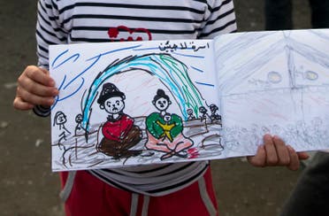 Shaharzad Hassan, 8 year-old from the Syrian city of Aleppo poses with a drawing she made at the northern Greek border station of Idomeni, Friday, March 11, 2016. At an overcrowded refugee camp on the Greek-Macedonian border, 8-year-old Shaharzad Hassan draws pictures of the harrowing events in her life over the past 18 months: Pictures of death in her home town of Aleppo, Syria, and her perilous journey to Europe. The title, of this drawing seen top right reads 