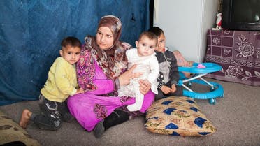 Dawlat sitting with her two daughters and one of her sons in her one room home in south Lebanon. (James Haines-Young)