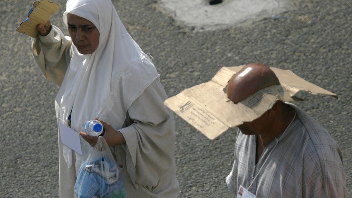 Muslim pilgrims walk as they cover their faces from the sun, after they performed the ritual Jamaraat. (AP)