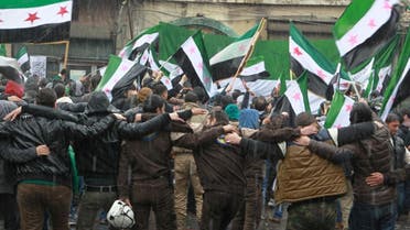 Civil defense members, rebel fighters and civilians carry opposition flags as they take part in a protest marking the fifth anniversary of the Syrian crisis in the old city of Aleppo, Syria March 15, 2016. (Reuters)