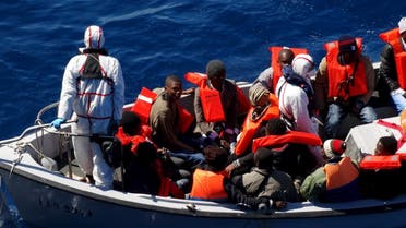 Migrants sit on a rescue boat during a rescue operation of migrants by Italian Navy vessels in this March 18, 2016 handout picture provided by Marina Militare. (Reuters/Marina Militare)