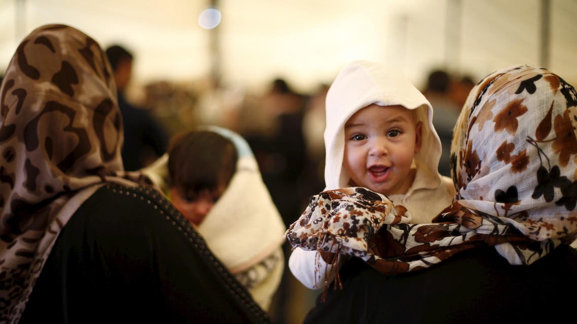 Syrian refugee mothers carry their babies during a ceremony at Al Zaatari refugee camp in the Jordanian city of Mafraq, near the border with Syria, March 1, 2016. (Reuters)