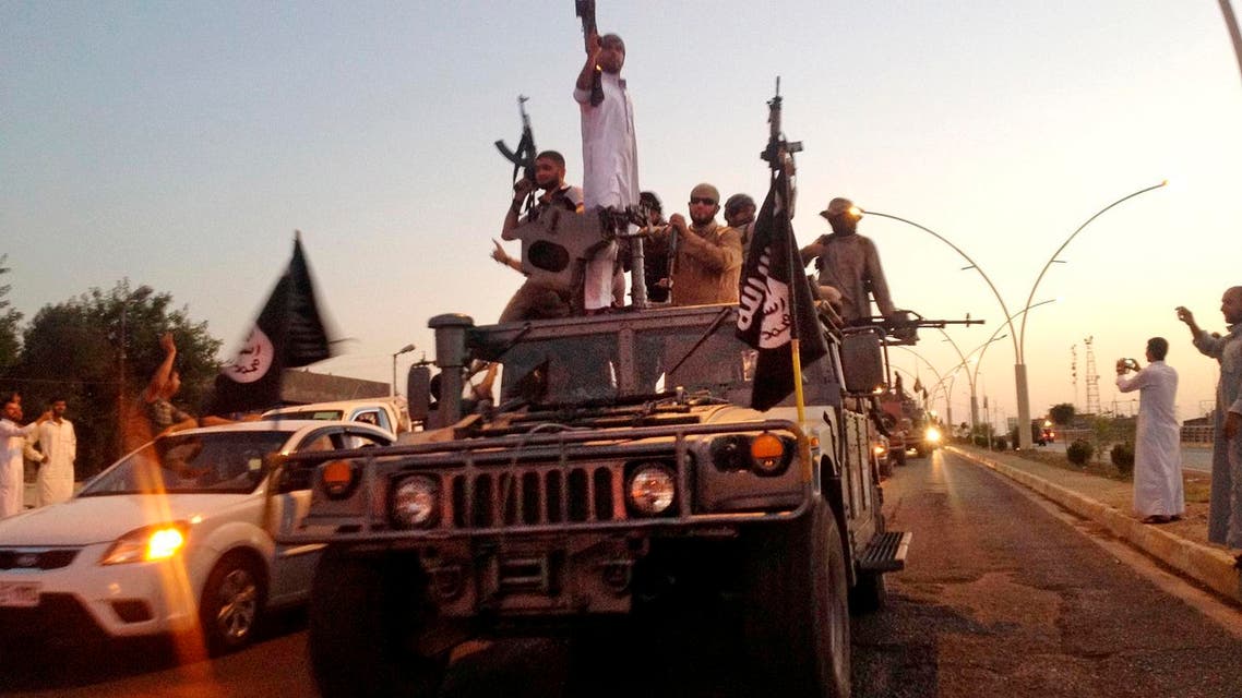In this file photo taken Monday, June 23, 2014, fighters from the Islamic State group parade in a commandeered Iraqi security forces armored vehicle on the main road at the northern city of Mosul, Iraq. Twelve years after the U.S. invaded Iraq to topple Saddam Hussein, the country is still mired in war. The latest phase: An existential battle against Islamic State group militants. For Iraqis, it feels like one long war, one that many blame on the United States. (AP Photo, File)