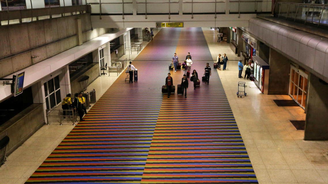 Passengers walk near departures gates at Simon Bolivar International Airport in Maiquetia near Caracas, Venezuela, Saturday, Dec 14, 2013. AP