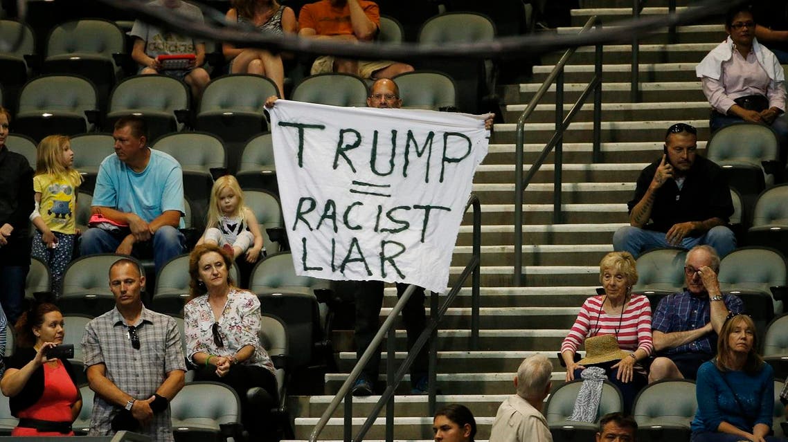 An anti-Donald Trump protester stands alone in the audience as the Republican presidential candidate speaks during a campaign rally Saturday, March 19, 2016, in Tucson, Ariz. (AP Photo/Ross D. Franklin)