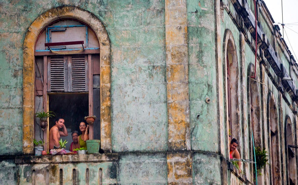 Local Cubans watch from their homes as the motorcade of then-US President Barack Obama arrives in a section of Old Havana. (File photo: AP)