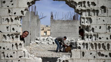 Boys play near rubble of damaged buildings in the rebel held besieged town of Douma, eastern Damascus suburb of Ghouta, Syria March 19, 2016. (Reuters)