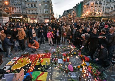 People bring flowers and candles to mourn at the Place de la Bourse in the center of Brussels, Tuesday, March 22, 2016. (AP)