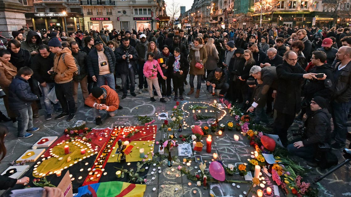 People bring flowers and candles to mourn at the Place de la Bourse in the center of Brussels, Tuesday, March 22, 2016. (AP)