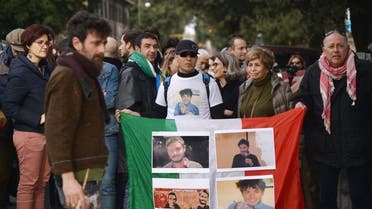 People hold an Italian flag with photos of Giulio Regeni, a Cambridge University PhD student who was found dead after disappearing in Cairo last month, during a demonstration in front of the Egypt's embassy in Rome on February 25, 2016 (AFP)