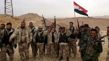 Forces loyal to Syria's President Bashar al-Assad flash victory signs and carry a Syrian national flag on the edge of the historic city of Palmyra in Homs Governorate, in this handout picture provided by SANA on March 26, 2016. (Reuters)