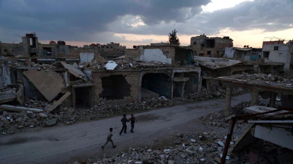 Syrian children walk past heavily damaged buildings in the rebel-held town of Douma, on the eastern edges of the capital Damascus on February 27, 2016, on the first day of the landmark ceasefire agreement (AFP)