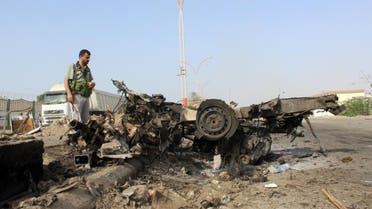 A man looks at the wreckage of a vehicle at the site of a suicide bombing in Yemen's southern port city of Aden March 26, 2016 (Reuters)