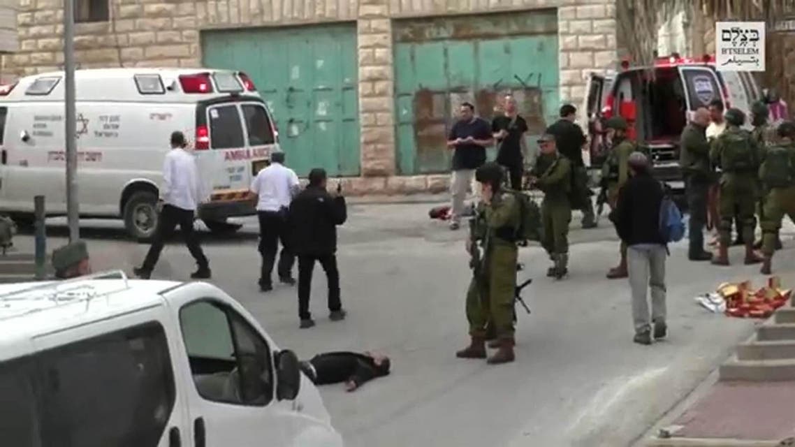 In this still from a video released by an Israeli human rights group, an Israeli soldier aims his weapon before apparently shooting and killing a wounded Palestinian assailant laying on the ground in the West Bank town of Hebron. (Photo courtesy: B'Tselem via AFP)