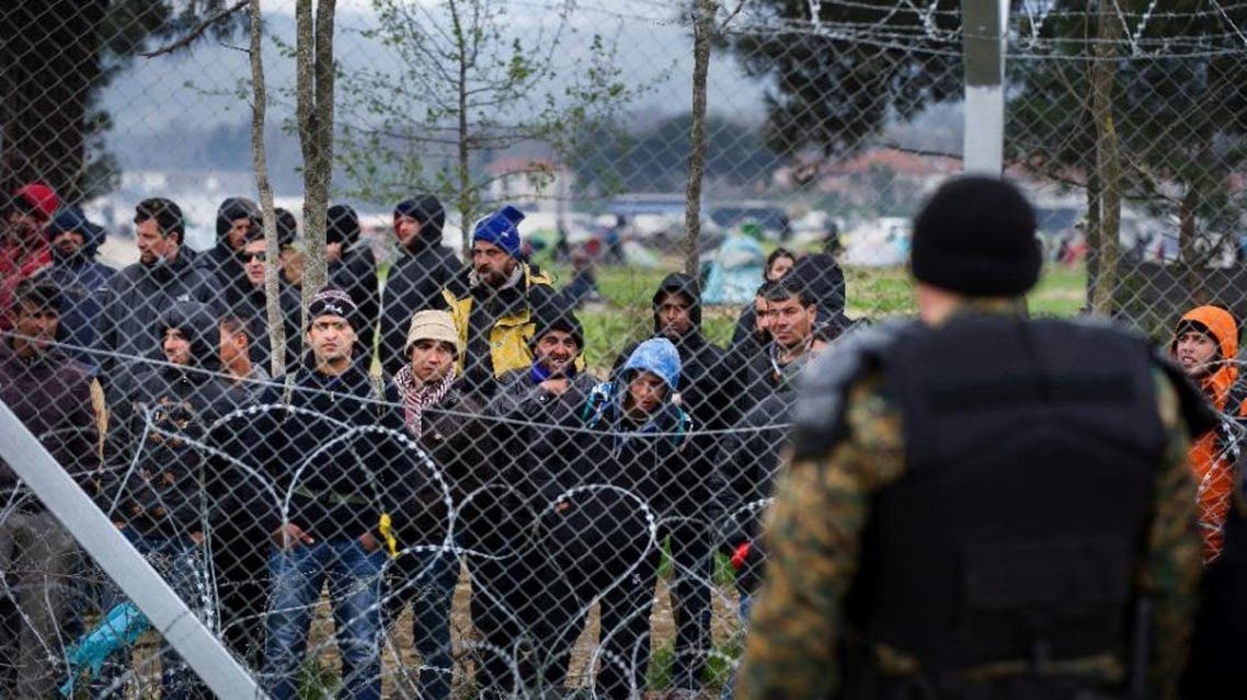 Migrants behind the fence at the Macedonian-Greek border on March 27, 2016, where thousands are stranded by the Balkan border blockade (AFP)