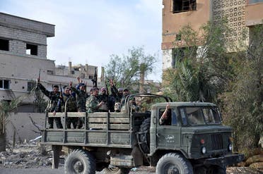 Forces loyal to Syria's President Bashar al-Assad flash victory signs while riding on the back of a military truck in Palmyra city, in Homs Governorate on March 27, 2016. (Photo courtesy: SANA)