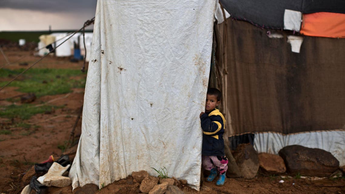 A Syrian refugee stands at the doorway of his family's tent at an informal tented settlement near the Syrian border, on the outskirts of Mafraq, Jordan, Monday, March 28, 2016. (AP Photo/Muhammed Muheisen)