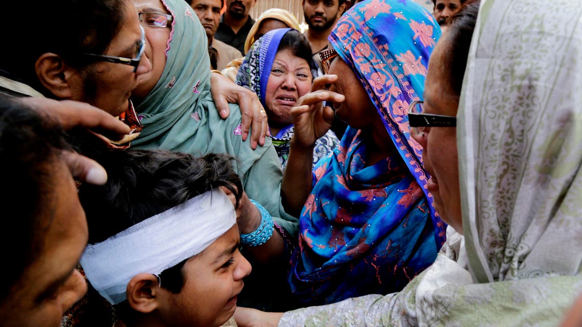 Eric John, bottom, who survived Sunday's attack, cries during the funeral of his cousin killed, in Lahore, Pakistan, Monday, March 28, 2016. The death toll from a massive suicide bombing targeting Christians gathered on Easter in the eastern Pakistani city of Lahore rose on Monday as the country started observing a three-day mourning period following the attack. (AP Photo/K.M. Chaudary)