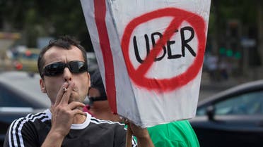 In this June 11, 2014 file photo, a demonstrator carries a mock coffin with a message reading 'They want to kill us - Uber' during a 24 hour taxi strike and protest in Madrid, Spain against unregulated competition from private companies, in particular, Uber. AP