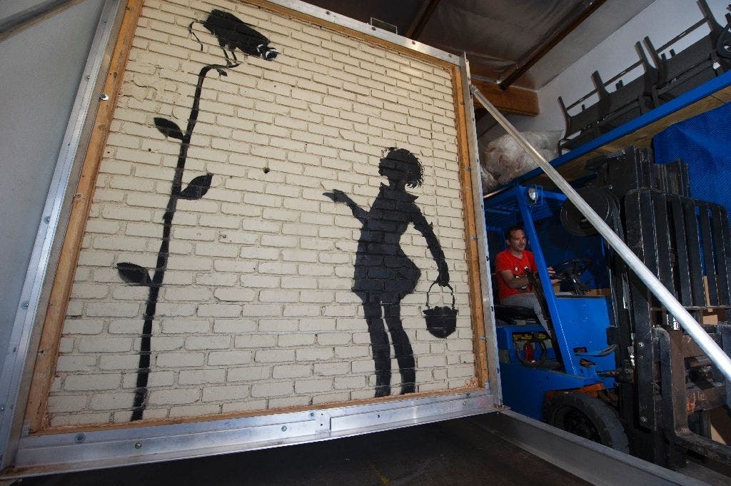 In December 2015, Julien's Auctions offered Banksy's 'Flower Girl', a piece painted on a gas station wall in Hollywood (AFP)
