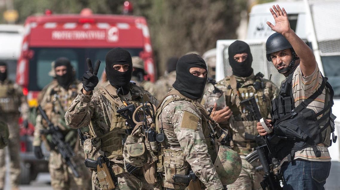 Tunisian soldiers celebrate at the end of a successful raid against gunmen in the Oued Ellil suburb of Tunis, Tunisia, Friday, Oct. 24, 2014. AP