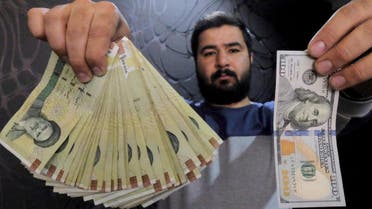 [Window Title] Enter name of file to save to…  [Content] A money changer poses for the camera with a U.S hundred dollar bill (R) and the amount being given when converting it into Iranian rials (L), at a currency exchange shop in Tehran's business district, Iran, January 20, 2016.  (Reuters) The file name is not valid.  [OK]