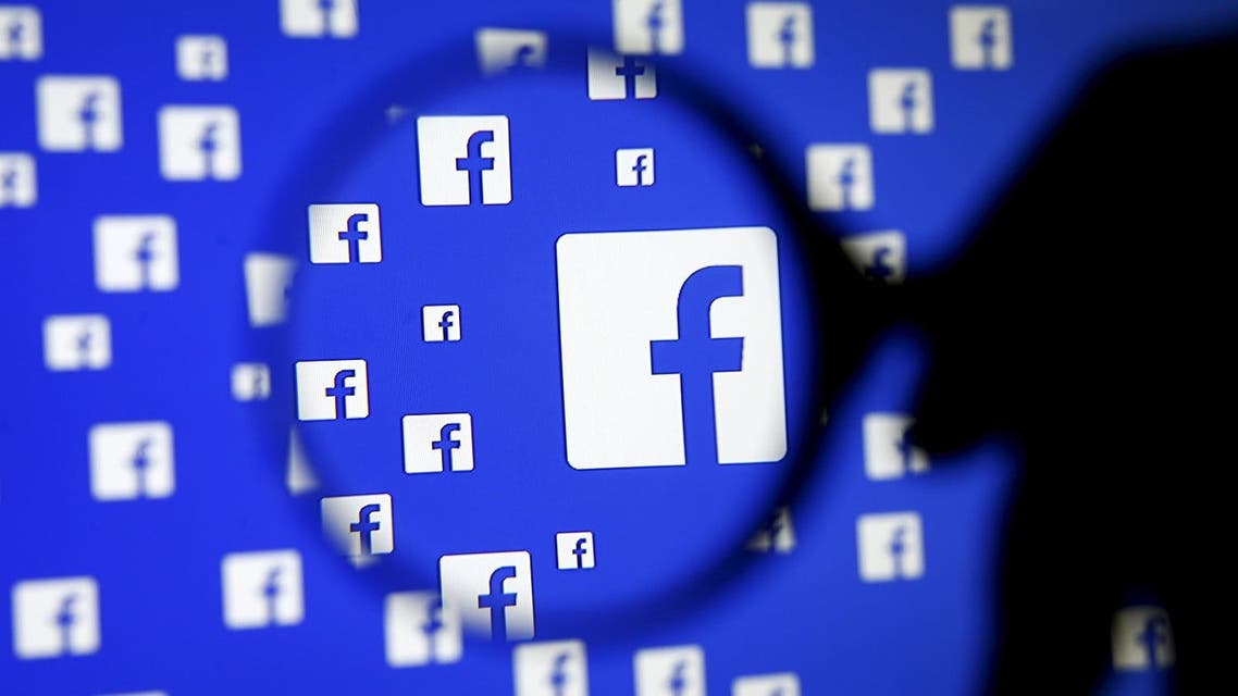 A man poses with a magnifier in front of a Facebook logo on display in this illustration taken in Sarajevo, Bosnia and Herzegovina, in this December 16, 2015, file photo. REUTERS