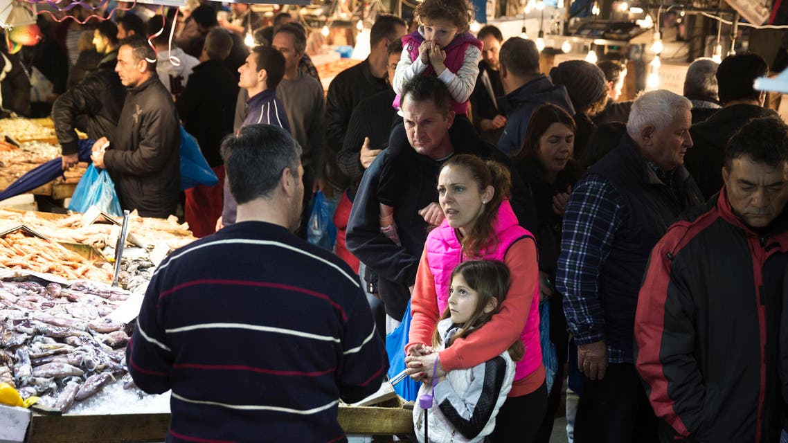 A family buys seafood at the fish market in Athens Monday, March 14, 2016. (AP)