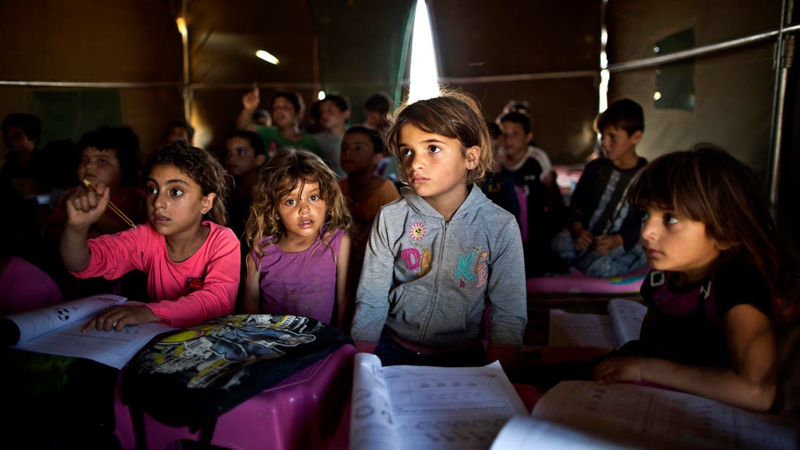 FILE - In this Tuesday, Aug. 11, 2015 file photo, Syrian refugee children attend a class at a makeshift school set up in a tent at an informal tented settlement near the Syrian border on the outskirts of Mafraq, Jordan. The U.N. agency for children says more than 80 percent of Syria's children have been harmed by the five-year-old conflict, including growing numbers forced to work, join armed groups or marry young because of widening poverty. (AP Photo/Muhammed Muheisen, File)