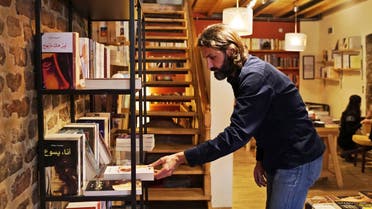  In this photo taken on Friday, April 1, 2016, Syrian refugee Samer Al-Kadri, founder and owner of Pages, a rustic three story-Arabic language bookshop, removes a book at his store in Istanbul, Turkey. The bookstore has become an anchor for many Syrians who have stayed put in Turkey but crave a taste of home. Al-Kadri, a refugee himself, says the store strives to be a bridge between Syrians, Turks and the myriad of foreigners who visit the city. Its weekly program includes oriental music concerts and, starting soon, language exchanges in Arabic, English and Turkish. Books are available in all three languages. (AP Photo/Bram Janssen)